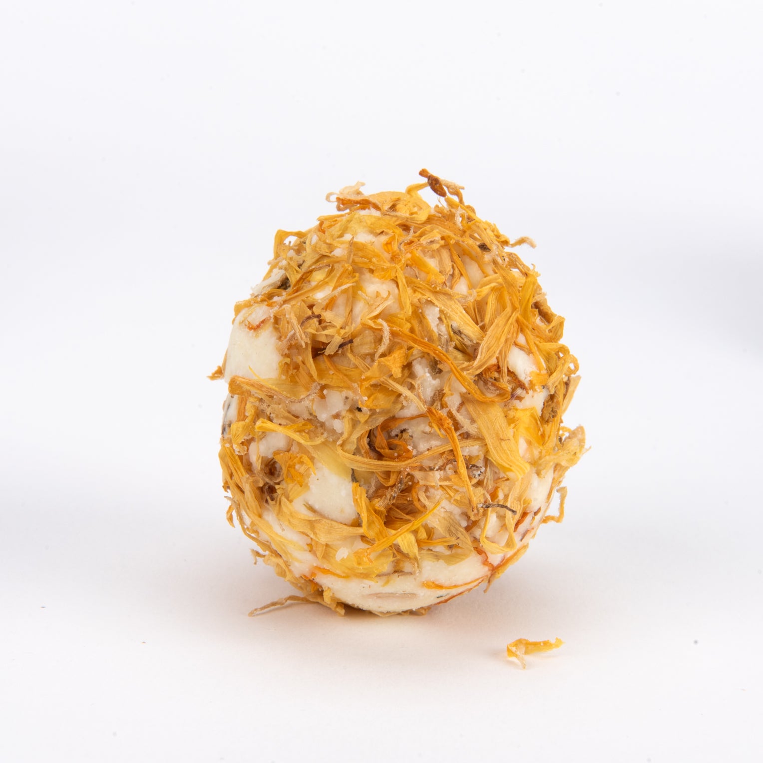A single bath melt featuring a white base wrapped in golden-yellow and orange dried mushroom threads, set against a plain white background.