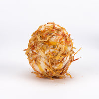 A spherical bath bomb made from dried orange calendula flowers and white soap, standing upright on a white background.