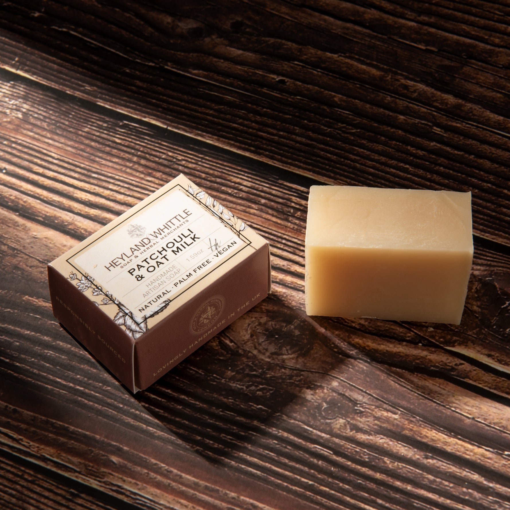 A rectangular bar of pale beige soap stands beside a small brown paper box labeled 